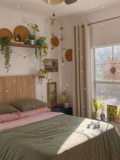 a bed sitting in a bedroom next to a window covered in green leaves and plants