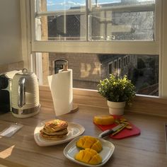 the breakfast is ready to be eaten on the table by the large window overlooking the city