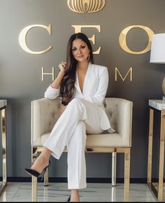 a woman sitting on a chair in front of a wall with the words coco h m