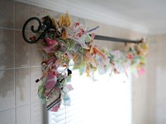 a close up of a decorative item hanging on a wall next to a window with blinds