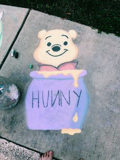 someone's feet are standing next to a chalk drawing of winnie the pooh