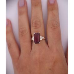 This dazzling 4.67-carat natural ruby looks stunning as the centerpiece of this ring. The ruby is emerald cut set in a classic 4-prong setting. The Platinum selected to hold this dazzling stone in place truly allows the ruby to shine. Standing to either side of the ruby are two trillion-cut diamonds, with a total weight of 0.82 carats.   Details: Item Type: Ring Metal: Platinum Size: 6.5 Weight: 5.75 Grams Setting: 4 Prong  Center Stone Details: Stone Type: Natural Ruby Carat: 4.67 Cut: Emerald Color: Red Setting: 4-Prong  Side Stones Details: Type: Natural Diamond Cut: Trillion Cut Color: White Carat: 0.82 Quantity: 2 Timeless Emerald-cut Ruby Ring, Gia Certified Baguette Cut Ruby Ring, Gia Certified Emerald Cut Ruby Ring, Gia Certified Ruby Jewelry With Baguette Cut, Gia Certified Baguette Cut Ruby Jewelry, Luxury Emerald-cut Ruby Ring, Fine Jewelry Ruby Ring With Rectangular Stone, Fine Jewelry Ruby Rings With Rectangular Stone, Emerald Cut Garnet Ruby Ring With Accent Stones