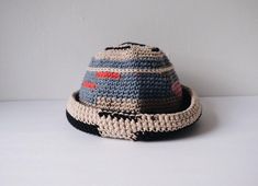 a crocheted hat sitting on top of a white table next to a wall