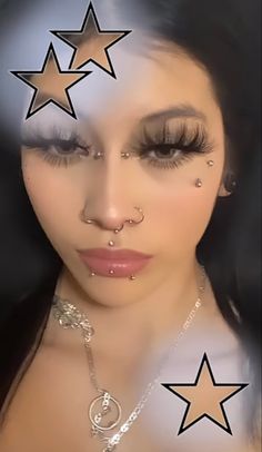 a woman with stars on her forehead and nose piercings in front of her face