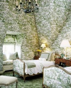 two beds in a room with green and white wallpaper