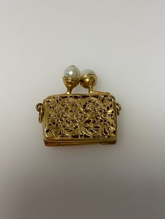 Vintage 14k yellow gold clutch purse with filigree design and pearl clasp charm. The purse opens up. The charm is 7.67 grams of gold. Yellow Gold Jewelry With Gold-tone Hardware For Evening, Elegant Gold-tone Jewelry As Gift, Evening Yellow Gold Jewelry With Box Clasp, Elegant Yellow Gold Openable Jewelry, Elegant Evening Jewelry With Gold Clasp, Elegant Gold Coin Purse For Formal Occasions, Classic Gold Coin Purse As Gift, Elegant Gold Coin Purse, Luxury Gold Coin Purse As Gift