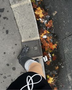 a person standing on the sidewalk with their feet up