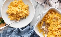 two plates with macaroni and cheese next to each other on a marble table