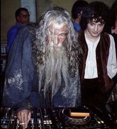 two people standing next to each other in front of a dj's turntable