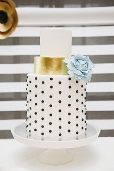 a white and black polka dot cake with blue flowers