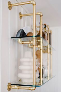 a shelf with glass shelves and gold fixtures