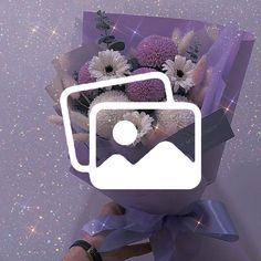 a bouquet of flowers is wrapped in purple paper and has a camera on the front