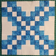 a blue and white quilt on a cutting board