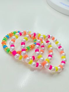 three bracelets with different colored beads on a table