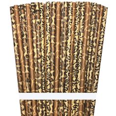 brown camouflage paper straws are lined up on a white tablecloth with black and gold designs