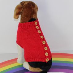 a stuffed dog wearing a red sweater with buttons