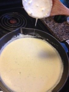 a pan filled with food sitting on top of a stove next to a wooden spoon