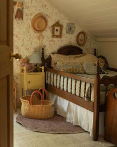 a bed room with a basket on the floor next to it and wall papered walls