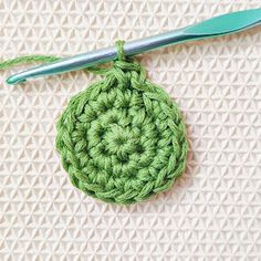 a crochet ornament is shown with a knitting needle in the middle