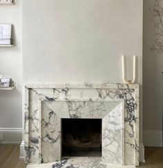 a marble fireplace in a living room with white walls