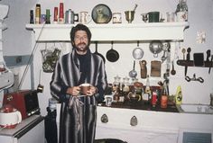 a man standing in a kitchen holding a cup