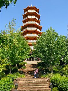 two people are standing at the bottom of some steps in front of a tall tower