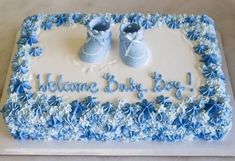 a welcome baby boy cake with blue shoes on it