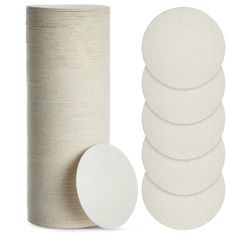 six white round discs next to a roll of toilet paper on a white background with the top off