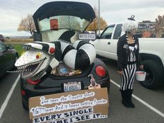 a woman standing in front of a car with its trunk open and stuffed animals inside