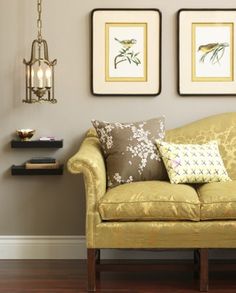 a living room with two framed pictures on the wall and a couch in front of it