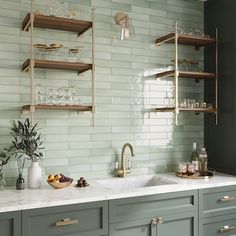 a kitchen with green cabinets and white marble counter tops is pictured in this image, there are shelves on the wall above the sink