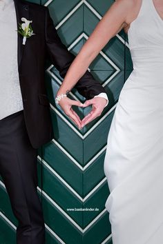 the bride and groom are holding their hands in the shape of a heart with one hand