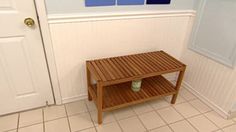 a small wooden table sitting in the corner of a room next to a white door