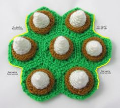 a crocheted green doily with four cookies and cream toppings on it