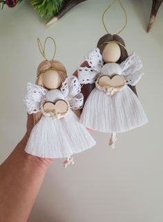 two handmade angel ornaments hanging from a christmas tree