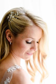 a woman with blonde hair wearing a white dress and holding a flower in her hand