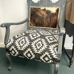 an old chair with a cow hide on it