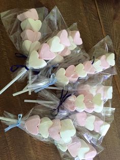 several heart shaped marshmallows wrapped in cellophane on a wooden table