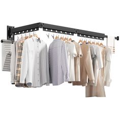 a rack with shirts and pants hanging on clothes hangers in front of a white background