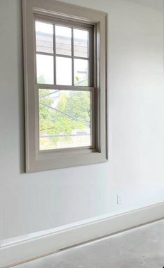 an empty room with white walls and a window