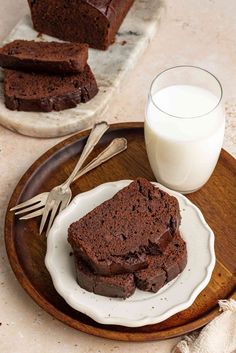 two slices of chocolate cake on a plate next to a glass of milk