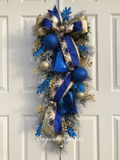 a blue and gold christmas wreath hanging on the front door