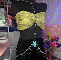 a mannequin wearing a yellow top and black skirt with beaded details on it