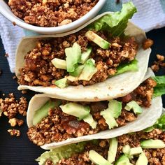 three tacos with meat and lettuce on top