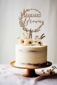 a white cake with flowers on top sitting on a table