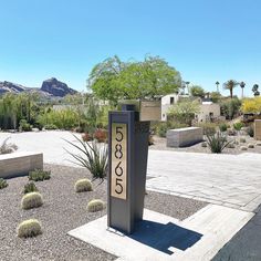 a sign that is sitting in the middle of some rocks and gravel with mountains in the background