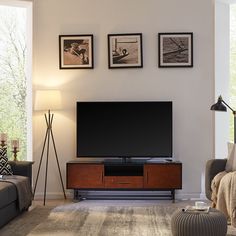 a flat screen tv sitting on top of a wooden stand in front of a window