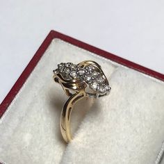 a gold ring with three diamonds on it in a red and white velvet gift box