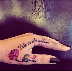 a woman's hand with a rose tattooed on it and the words talk as old as time