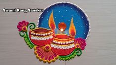 a decorated diya with two lit candles on it, and the words swami rang sank